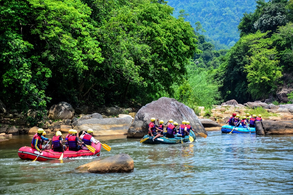 Grupa ljudi sa tri camca na raftingu rekom.